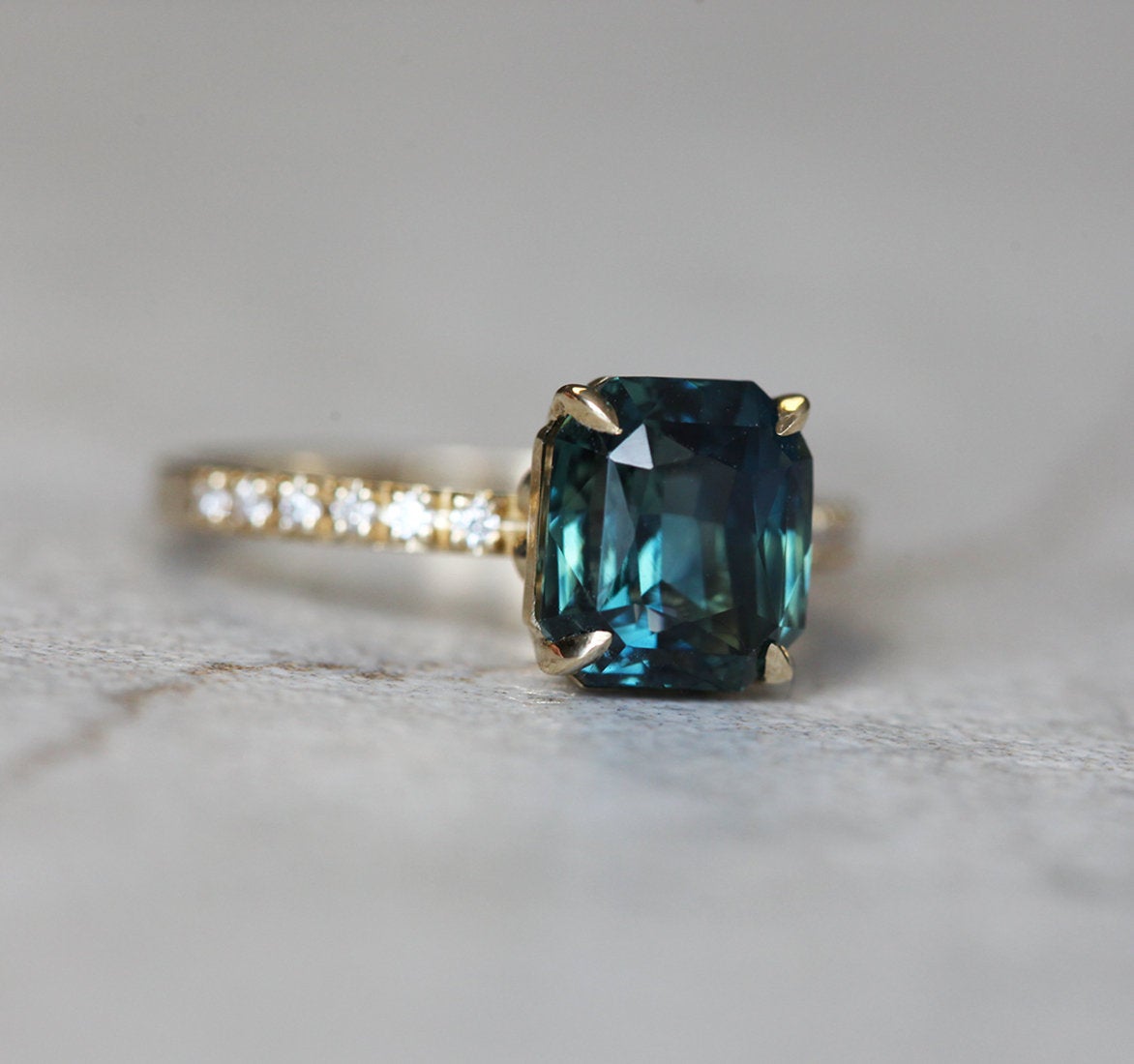 Radiant teal sapphire ring with nested diamonds and tourmaline