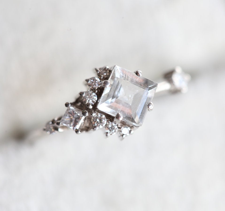 Square-shaped white sapphire ring with diamond cluster