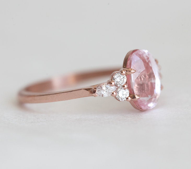 Oval-shaped peach sapphire ring with side diamonds