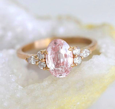 Oval-shaped peach sapphire ring with side diamonds