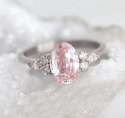 Oval-shaped peach sapphire ring with side diamonds