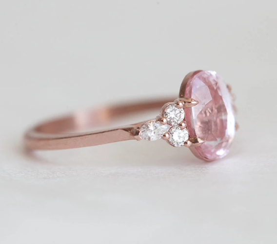 Oval-shaped peach sapphire ring with side diamonds