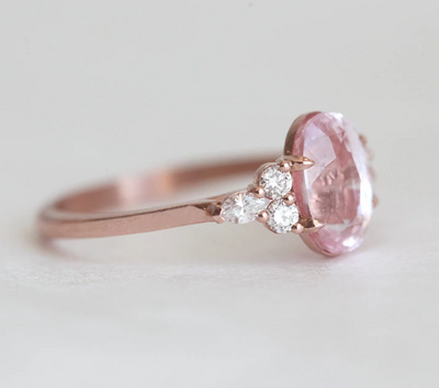 Oval-shaped peach sapphire ring with side diamonds