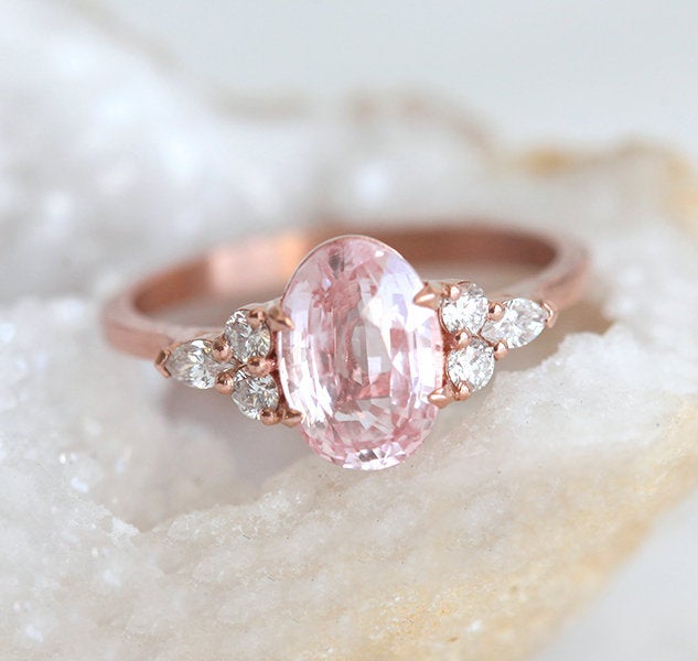 Oval-shaped peach sapphire ring with side diamonds