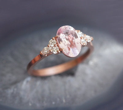 Oval-shaped peach sapphire ring with side diamonds