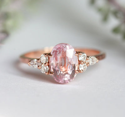 Oval-shaped peach sapphire ring with side diamonds