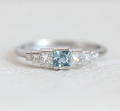 Princess-shaped teal sapphire ring with side diamonds