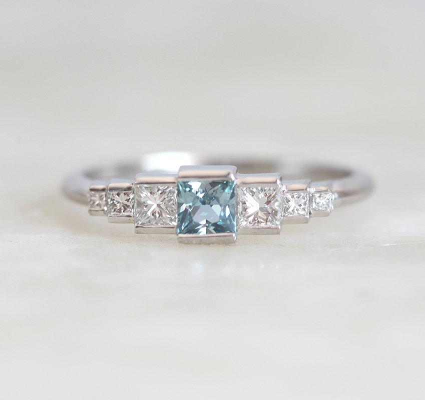 Princess-shaped teal sapphire ring with side diamonds