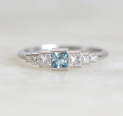 Princess-shaped teal sapphire ring with side diamonds