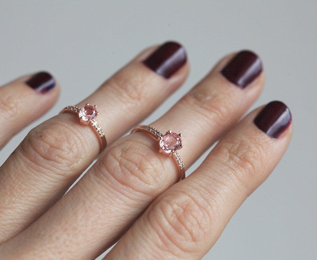 Two oval-shaped peach sapphire rings with side diamonds