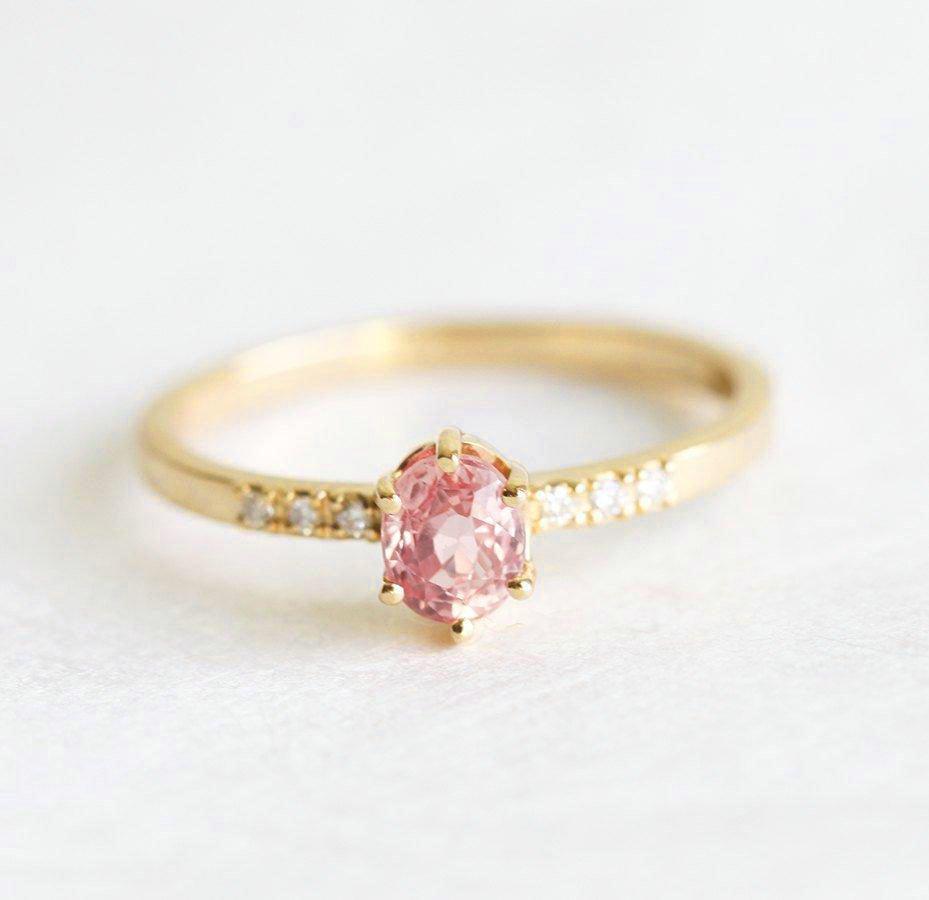 Oval-shaped peach sapphire ring with side diamonds