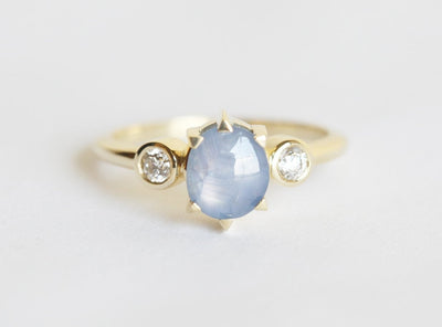 Blue-colored round sapphire ring with side diamonds