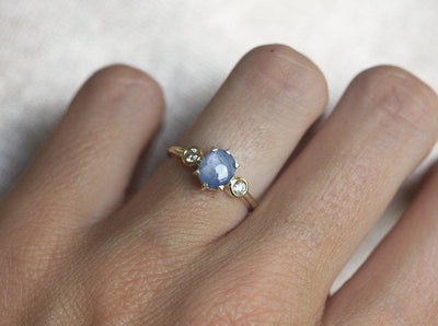 Blue-colored round sapphire ring with side diamonds
