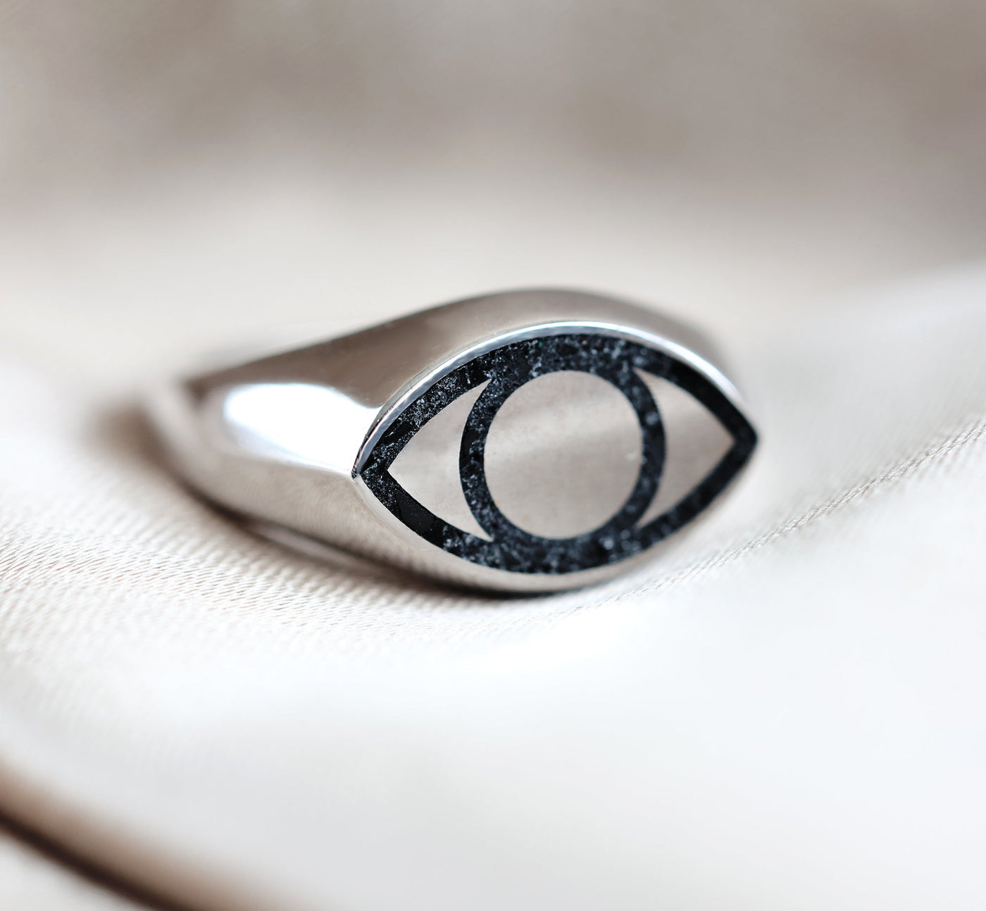 Gold or platinum signet ring with black spinel inlay, featuring an all-seeing eye design. Unisex, polished finish, customizable gemstones.