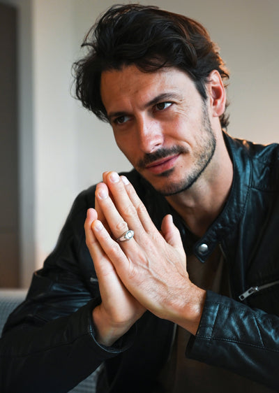 A man's hands showcasing an All-Seeing Eye black spinel inlay signet ring.