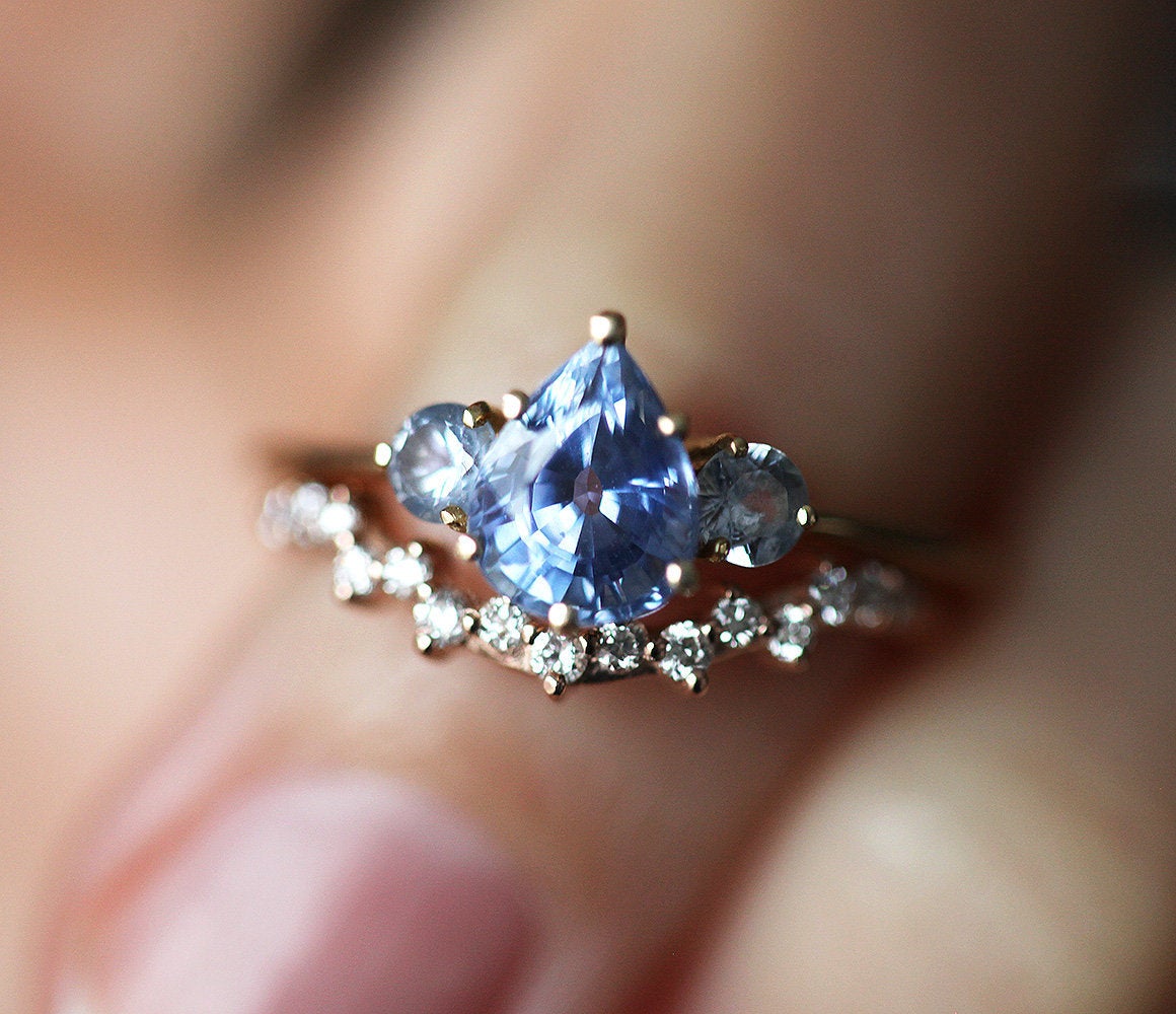 Pear-shaped blue sapphire ring with round side diamonds