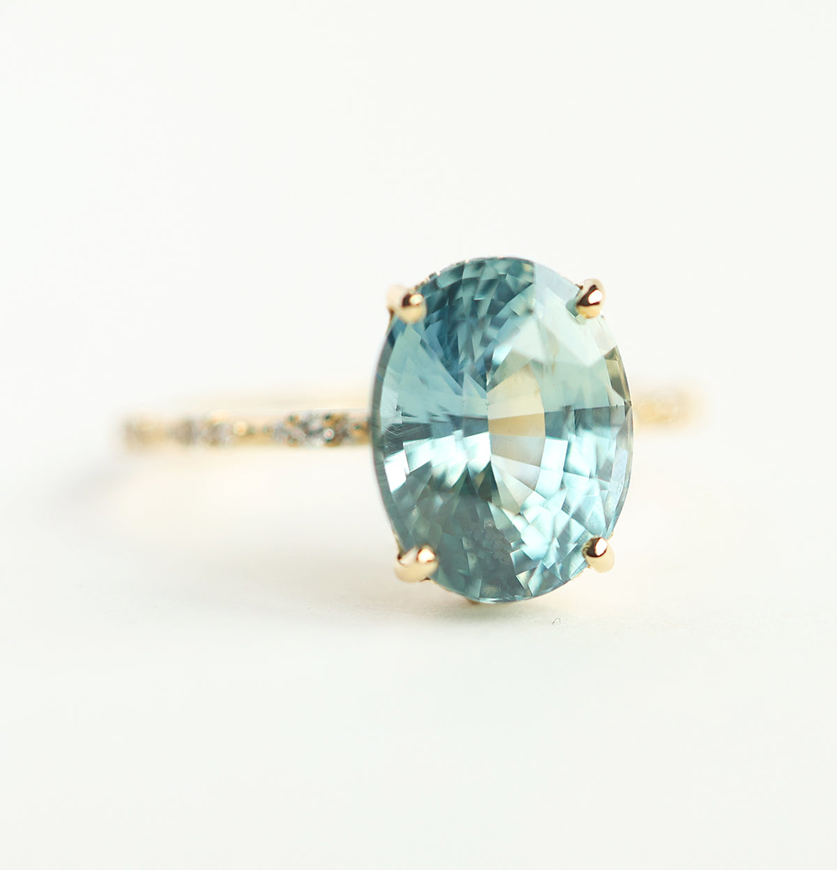 Mint-colored oval sapphire engagement ring with side diamonds