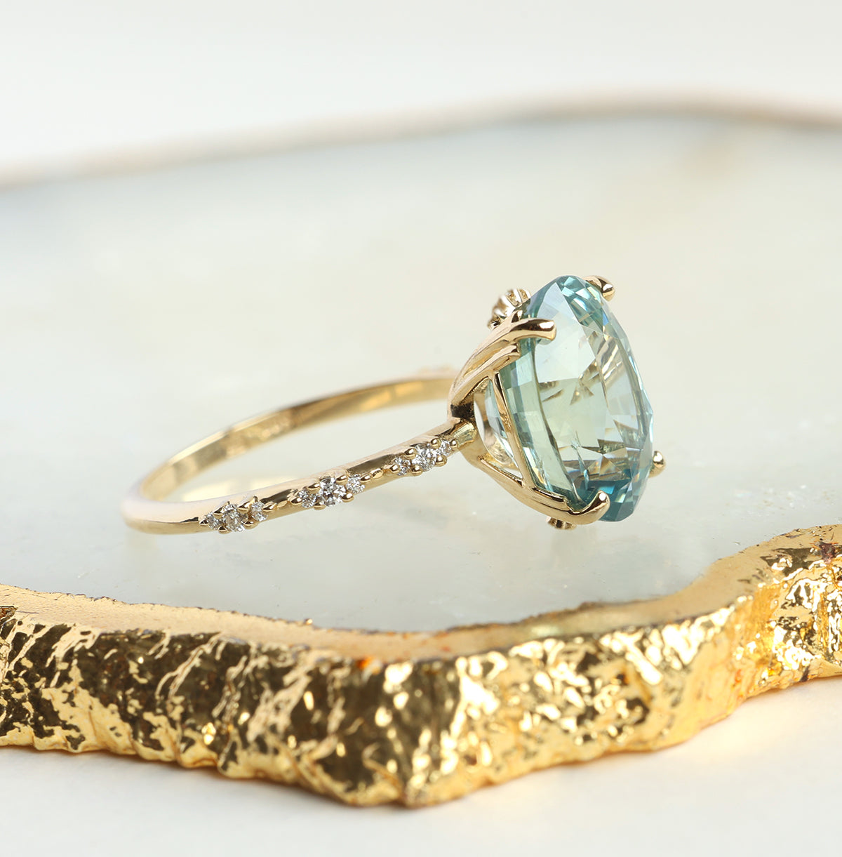 Mint-colored oval sapphire engagement ring with side diamonds