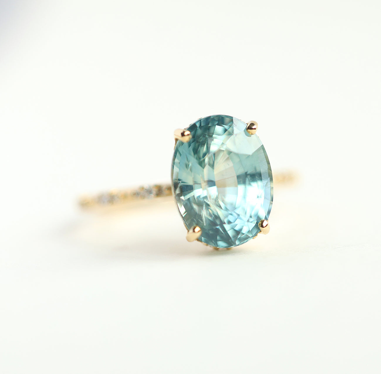 Mint-colored oval sapphire engagement ring with side diamonds