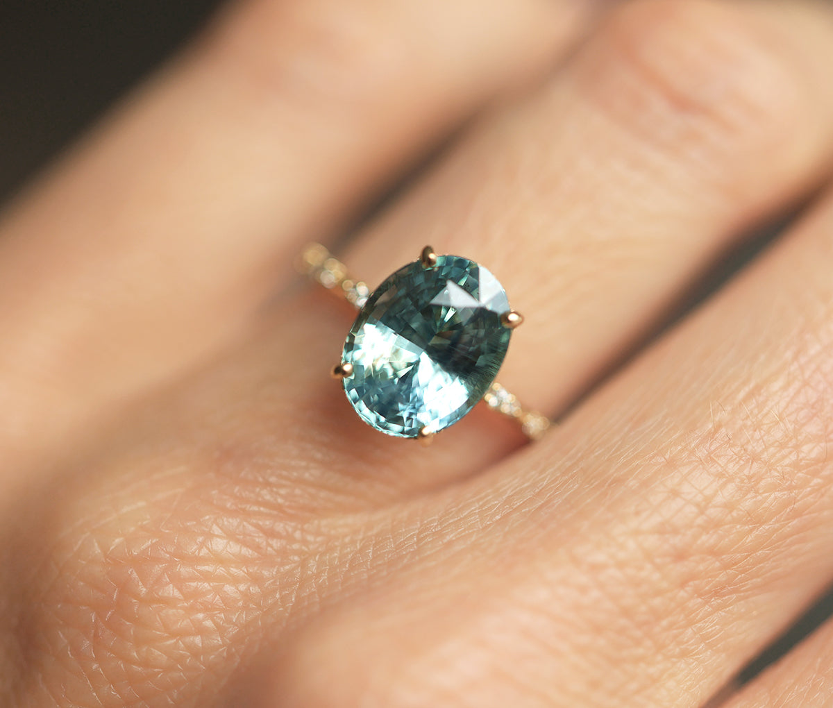 Mint-colored oval sapphire engagement ring with side diamonds