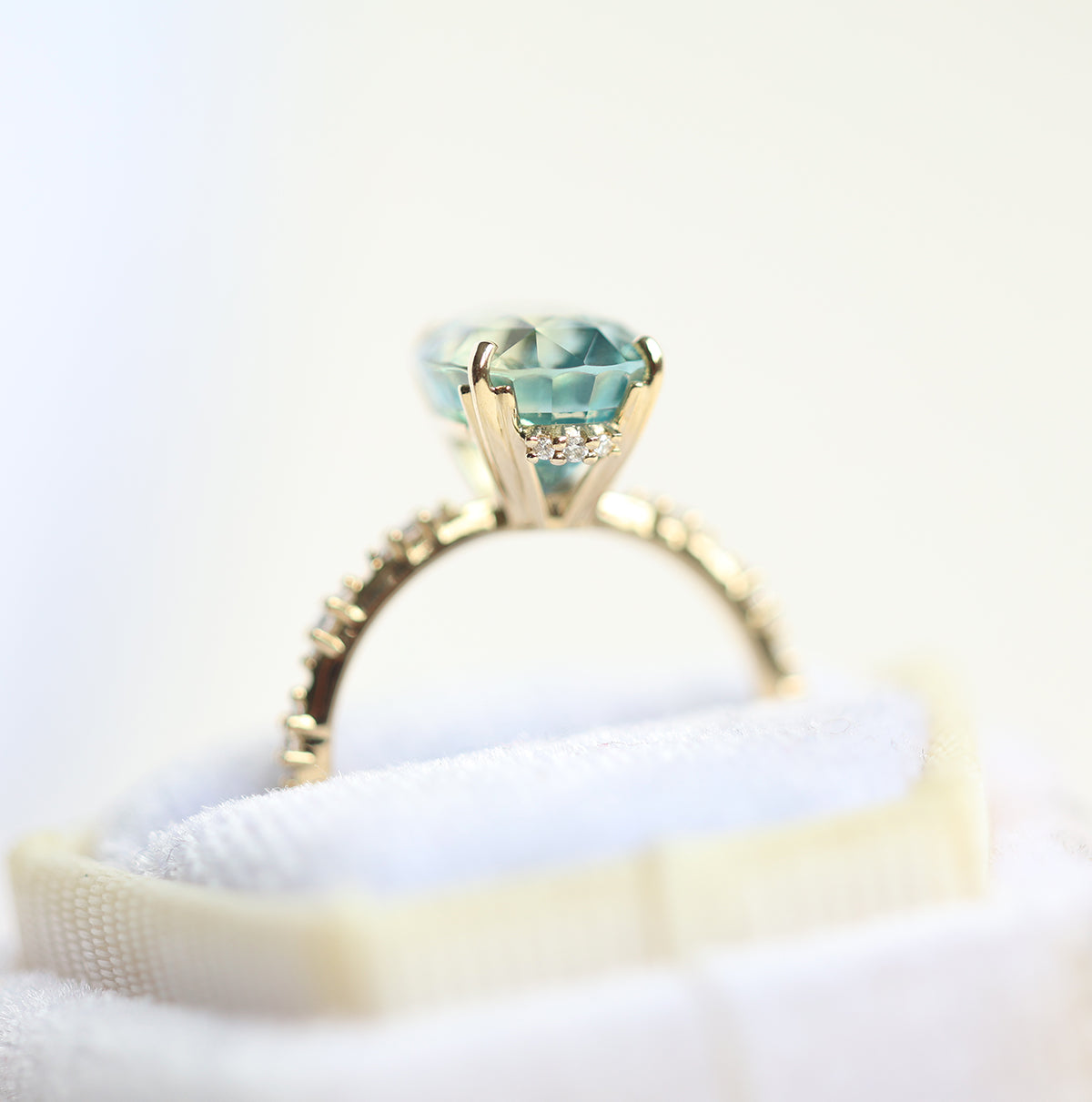 Mint-colored oval sapphire engagement ring with side diamonds