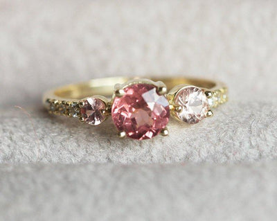 Round red garnet cluster ring with side diamonds and sapphires