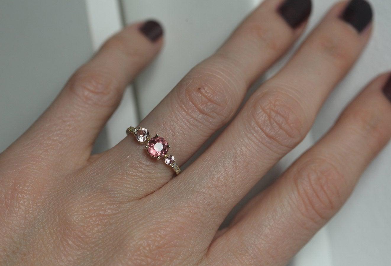 Round red garnet cluster ring with side diamonds and sapphires