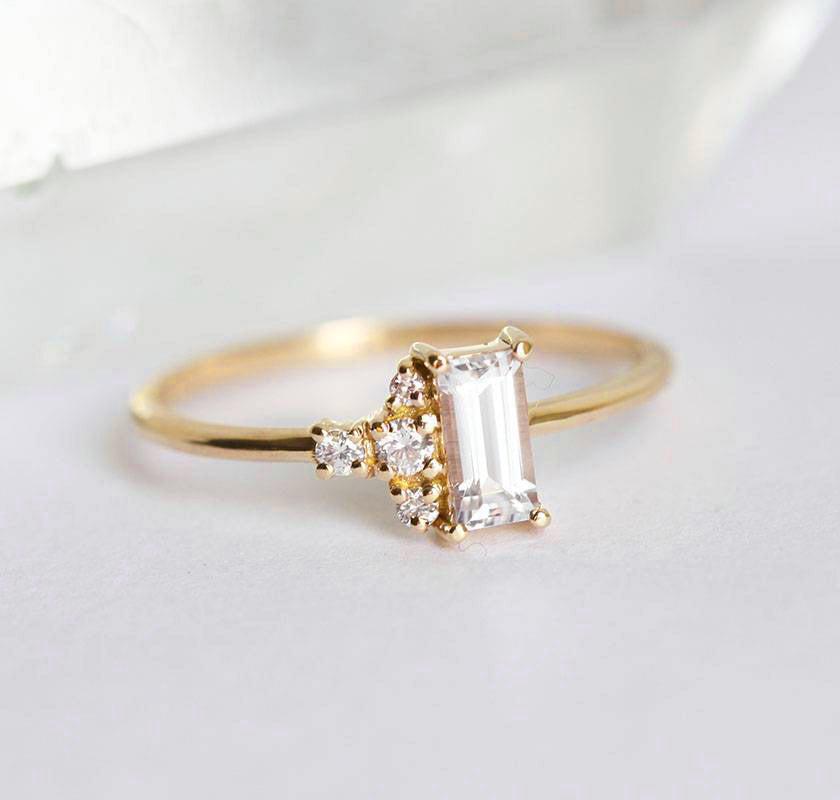 Baguette-shapped white sapphire cluster ring with side diamonds