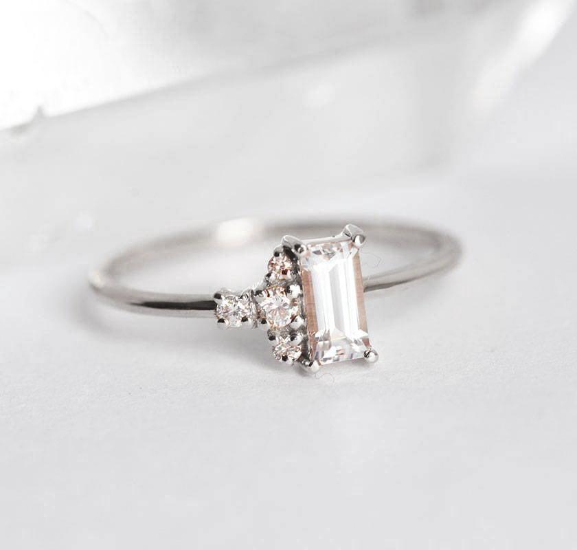 Baguette-shapped white sapphire cluster ring with side diamonds