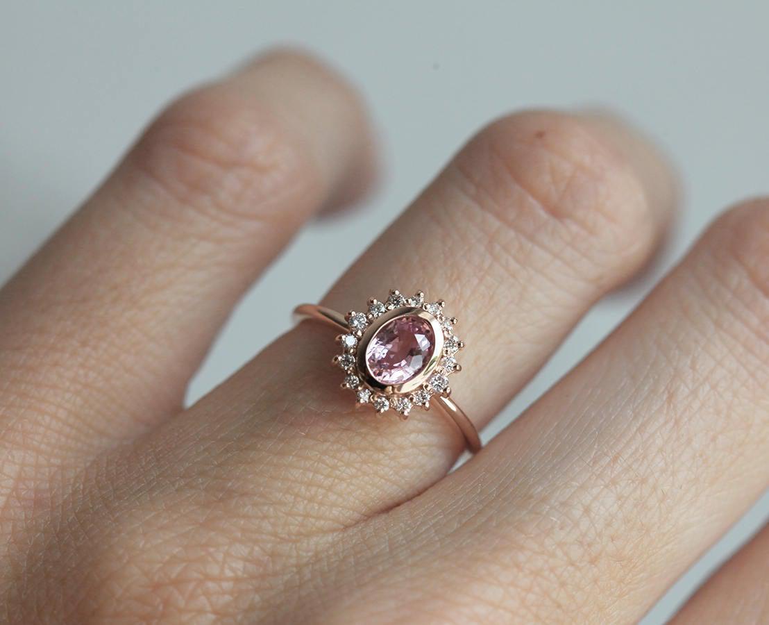 Pink oval-shaped sapphire halo ring with side diamonds