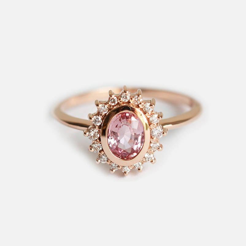 Pink oval-shaped sapphire halo ring with side diamonds