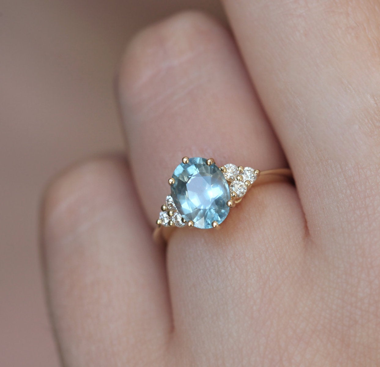 Light blue oval-shaped sapphire ring with diamond nesting