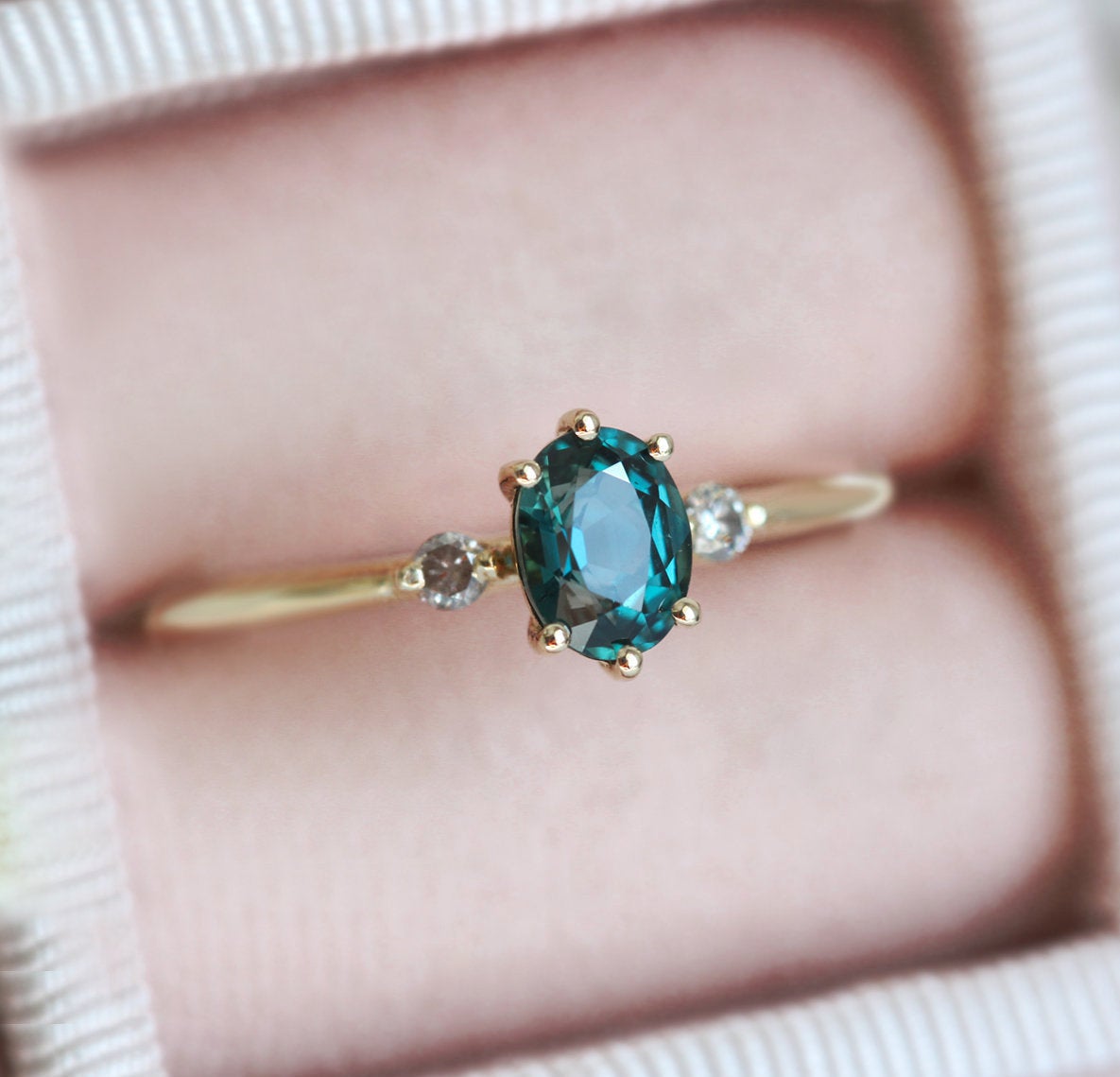 Oval-shaped teal sapphire ring with side diamonds