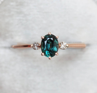 Oval-shaped teal sapphire ring with side diamonds
