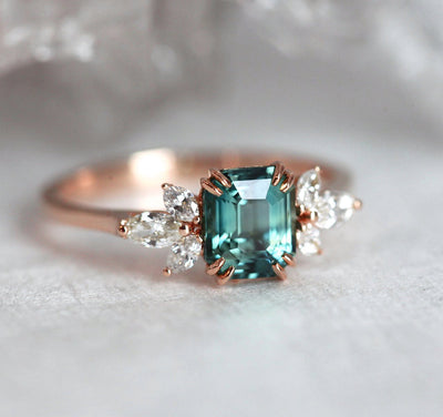 Emerald-shaped teal sapphire ring with diamond cluster
