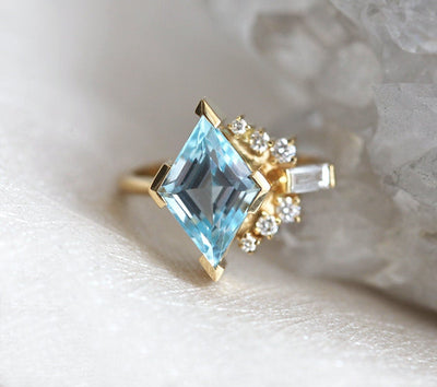 Kite-shaped peach sapphire ring with diamond cluster