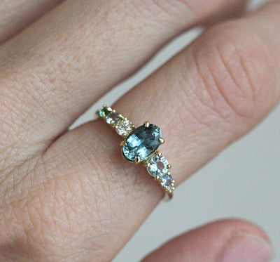 Oval-shaped blue sapphire ring with gemstone cluster
