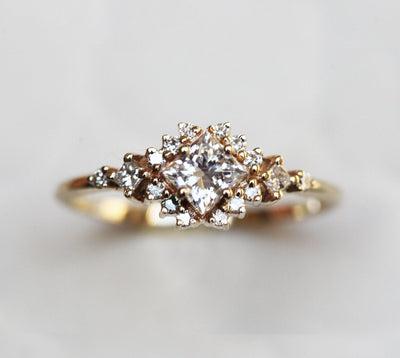 Gold ring with princess cut diamond centerpiece and side diamond clusters