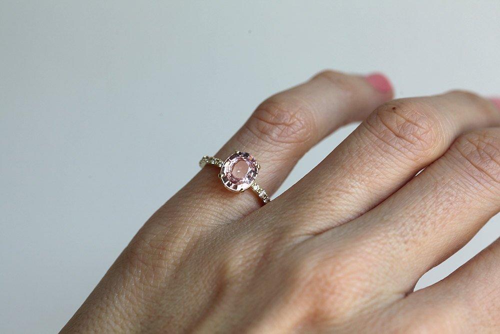Oval-shaped light peach pink sapphire ring with side diamonds