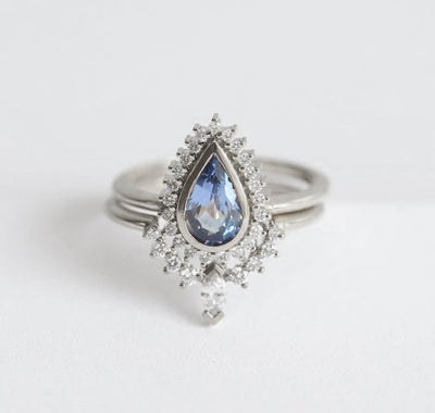 Pear-shaped blue sapphire engagement ring with white diamond halo