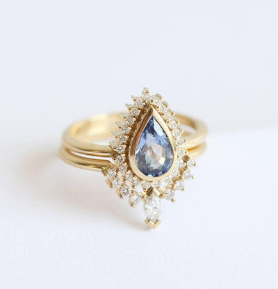 Pear-shaped blue sapphire engagement ring with white diamond halo