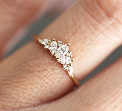 Elegant gold ring with a cluster of marquise, square, and round cut white diamonds in a floral design