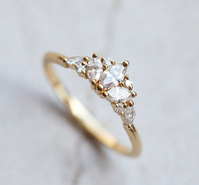 Elegant gold ring with a cluster of marquise, square, and round cut white diamonds in a floral design