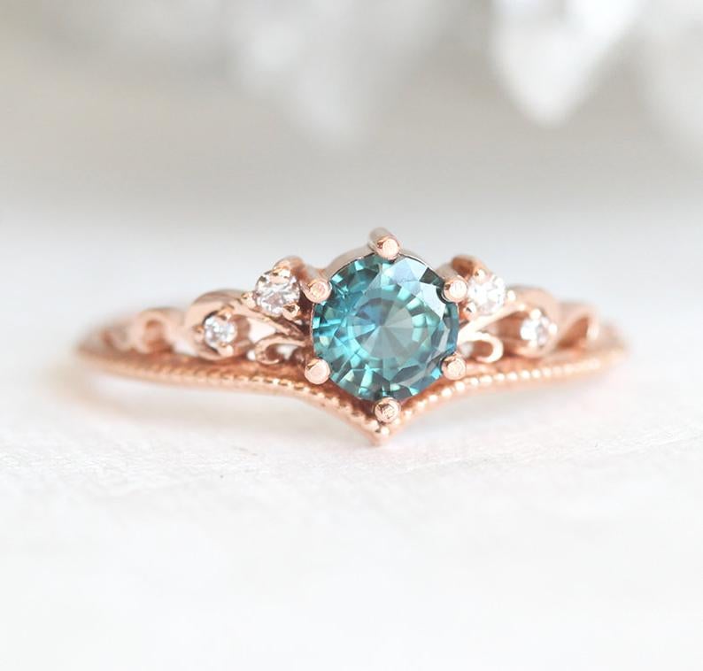 Round teal sapphire engagement ring with nested white diamonds