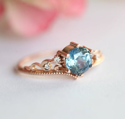 Round teal sapphire ring with white side diamonds