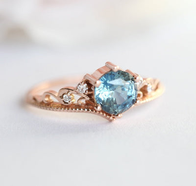 Round teal sapphire ring with white side diamonds