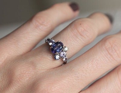 Blue oval-shaped sapphire ring with diamond cluster