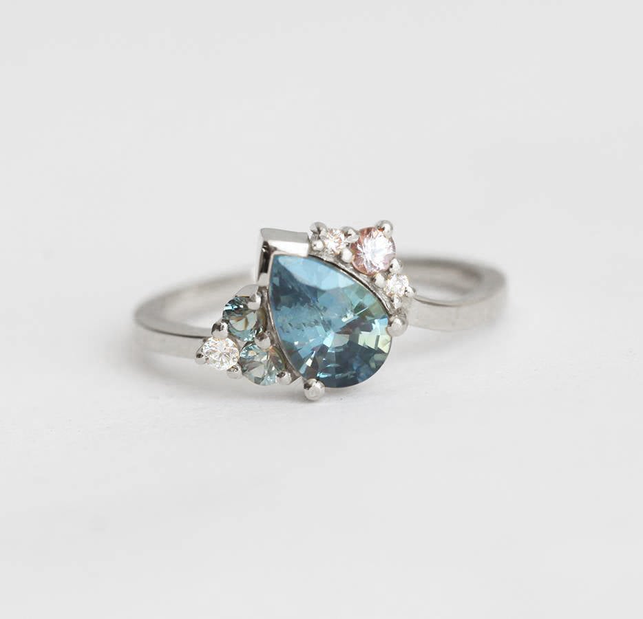 Blue pear-shaped sapphire ring with diamond cluster