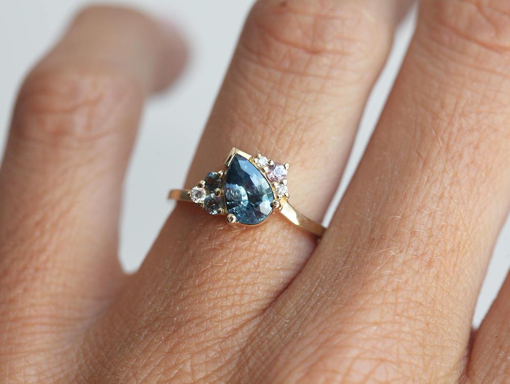 Blue pear-shaped sapphire ring with diamond cluster