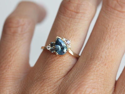 Blue pear-shaped sapphire ring with diamond cluster